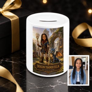 Può includere: Un salvadanaio in ceramica bianca con un'illustrazione stampata di una giovane persona con lunghe trecce scure che tiene un bastone, accanto a un piccolo drago blu. Il testo DRAGON TRAINER ELLA SKY RIDER ACADEMY è sopra una piccola foto.