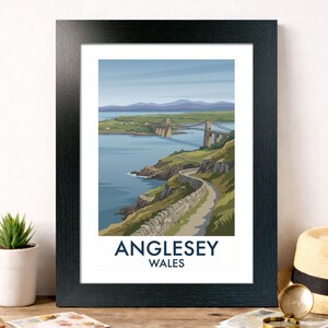 Puede incluir: Impresión enmarcada de Anglesey, Gales, con un puente sobre un mar azul. La imagen muestra una carretera costera, colinas verdes y un cielo azul. El texto "Anglesey Wales" está impreso en la parte inferior de la obra, en un marco negro.
