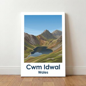 May include: A canvas print showcasing the Cwm Idwal landscape in Wales. The artwork presents a tranquil lake nestled amidst mountains under a clear blue sky. The text "Cwm Idwal Wales" is displayed at the bottom in a navy blue font.