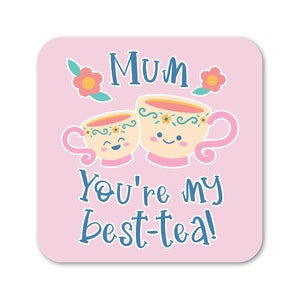 Pode incluir: Copo de apoio quadrado rosa com uma ilustração fofa de duas xícaras de chá com rostos. O texto "Mum you're my best-tea!" está escrito em azul abaixo das xícaras de chá.
