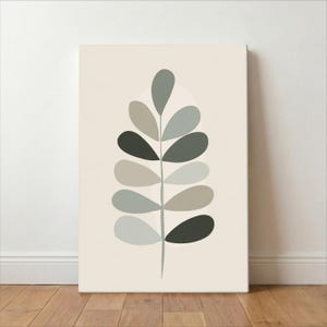 May include: A canvas print featuring a minimalist botanical design. The artwork showcases a stylized leaf with a stem and multiple leaf shapes in shades of gray and green against a cream background. The print is mounted on a wooden frame.