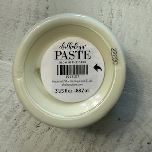 May include: A round container of Chalkology Paste in a glow-in-the-dark formula. The white label features the text Chalkology PASTE GLOW IN THE DARK, a barcode, the number 22200, and the volume measurement of 3 US fl oz or 88.7 ml.