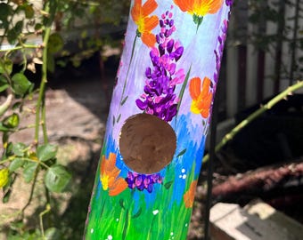 Casa para pájaros con forma de calabaza larga y flores de verano