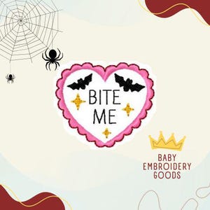 Puede incluir: Parche bordado en forma de corazón rosa con el texto "Bite Me" en blanco. Dos murciélagos negros están bordados a cada lado del texto. Hay estrellas doradas brillantes a cada lado del texto.