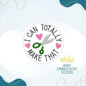 May include: A white circular patch with the text "I CAN TOTALLY MAKE THAT" in black. The patch features a pair of silver scissors, three pink hearts, and the words "Baby Embroidery Goods" below a gold crown.