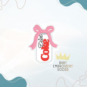 May include: Embroidered patch featuring a Diet Coke can design with red text and a pink bow. The patch has a white background and a silver border. The text "Baby Embroidery Goods" is also visible.