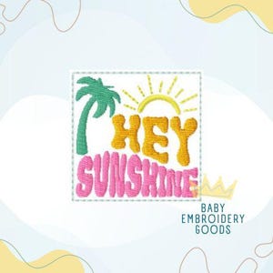 May include: Embroidered square with the words "HEY SUNSHINE" in yellow and pink, a green palm tree, and a yellow sun. The text "BABY EMBROIDERY GOODS" is below a small gold crown.