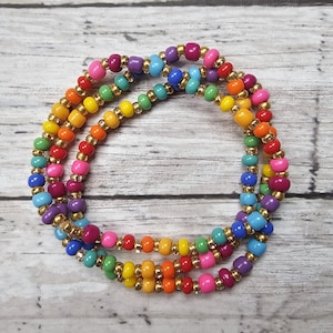 May include: A multi-strand beaded bracelet with rainbow colored beads and gold accents.