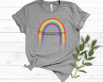 May include: Gray t-shirt with a rainbow graphic dripping down. The rainbow is a visual representation of the definition of a rainbow: "any display of the colors of the spectrum produced by dispersion of light."