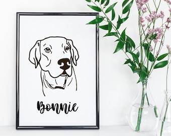 May include: Black and white line art print of a dog's head with the name "Bonnie" written below. The print is framed in a black frame and is displayed on a white surface.