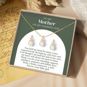 May include: A gold-colored necklace and earring set with pearl accents, presented in a gift box. The box features text that reads "To My Mother On My Wedding Day" and a heartfelt message.