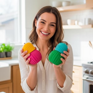 May include: A woman holds two sets of colourful kitchen gadgets. One set is yellow and pink, the other is green and teal. Each set consists of two pieces, a ribbed base and a smooth, rounded top. The kitchen setting suggests these are food storage containers.