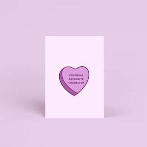 Tarjeta de San Valentín con temática de libros en color lila "Eres mi personaje favorito", tarjeta con corazón de caramelo rosa, tarjeta de felicitación con temática de libros