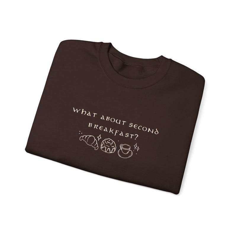 May include: A brown t-shirt with the text "What about second breakfast?" in white with a croissant, a pastry, and a cup of coffee illustration.