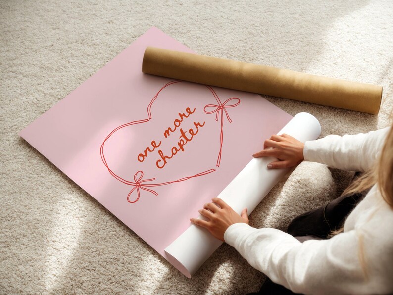 May include: A pink poster with a red heart outline and the words "one more chapter" in red script. A rolled-up white poster and a brown cardboard tube are also visible. The image is taken from an overhead perspective.