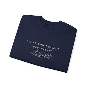 May include: Navy blue t-shirt with the text "What about second breakfast?" in white with a graphic of a croissant, a pastry, and a cup of coffee.