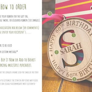 A round wooden ornament with the text "Happy 60th Birthday" and the letter "S" cut out. The name "Sarah" is written inside the letter "S".