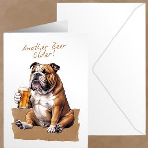 May include: A greeting card featuring a cartoon bulldog holding a glass of beer. The card has the text "Another Beer Older!" in brown lettering.