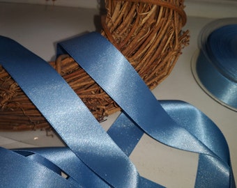 May include: Two rolls of light blue satin ribbon with a subtle shimmer. The ribbon is displayed on a brown twig wreath.