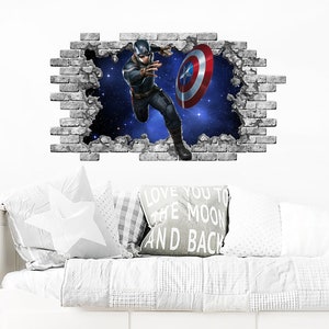 Può includere: Un adesivo da parete con Captain America che rompe un muro di mattoni. Sta tenendo il suo scudo e volando nell'aria. Lo sfondo è un cielo stellato blu e bianco.