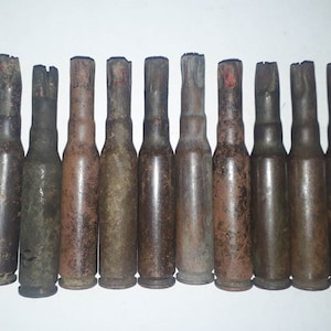 May include: Ten empty, rusty, brown bullet casings.