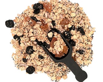 May include: A close-up of a black scoop filled with granola, dried fruit, and seeds. The granola is a mixture of oats, nuts, and seeds. The dried fruit is a mixture of raisins, cranberries, and apricots. The seeds are a mixture of sunflower seeds, pumpkin seeds, and chia seeds.