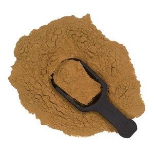 May include: A brown powder with a black scoop. The powder is in a pile and the scoop is partially filled with the powder.
