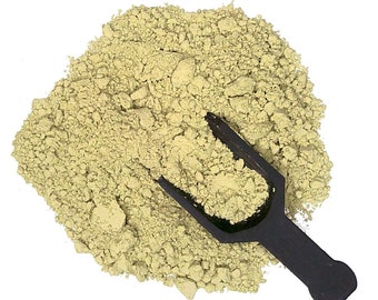 May include: A scoop of light green powder on a white background. The powder is in a small pile and a black plastic scoop is lying on top of it.