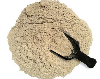 May include: A close-up of a pile of light brown powder with a black scoop on top. The powder is likely a type of flour or baking ingredient.