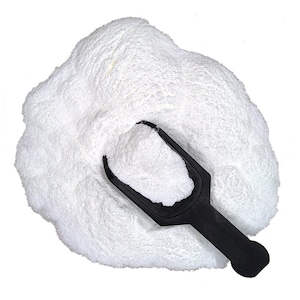 May include: A white powder with a black plastic scoop. The powder is piled high and the scoop is partially buried in the powder.