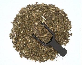 May include: A close-up of a pile of dried green herbs with a black plastic scoop. The herbs are loose and appear to be finely chopped.