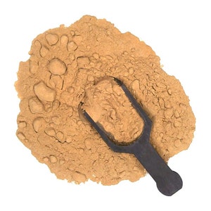 May include: A close-up of a pile of light brown powder with a black scoop. The powder is a natural ingredient used in cooking and baking.