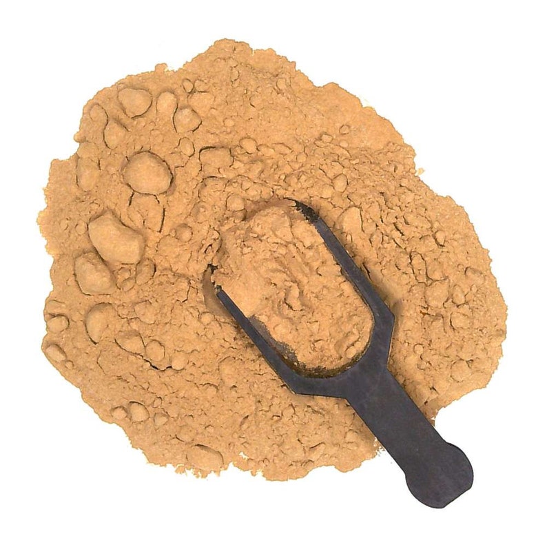 May include: A close-up of a pile of light brown powder with a black scoop. The powder is a natural ingredient used in cooking and baking.