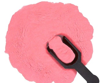 May include: A scoop of pink powder with a black plastic scoop on top.