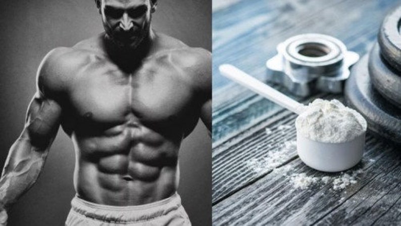 Puede incluir: Una foto en blanco y negro de un hombre musculoso de pie frente a un fondo gris. Una cuchara blanca de prote&iacute;na en polvo est&aacute; sobre una superficie de madera con una placa de peso y un mango de m&aacute;quina de pesas en el fondo.