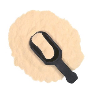 May include: A scoop of beige powder with a black plastic scoop on top.