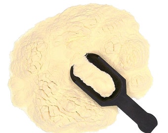 May include: A large pile of yellow powder with a black scoop on top. The powder is likely a food ingredient or supplement.
