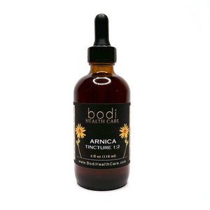May include: A brown glass bottle with a black dropper top and a black label that reads "bodi HEALTH CARE ARNICA TINCTURE 1:2 4 fl oz (118 ml) www.BodiHealthCare.com".