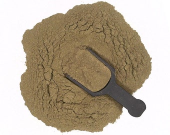 May include: A pile of loose, brown powder with a black plastic scoop on top. The powder is likely a spice or herb.