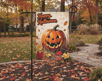 May include: A Halloween garden flag featuring a smiling jack-o'-lantern with the words "Happy Halloween." The pumpkin is orange with a green stem, surrounded by autumn leaves. The flag is displayed outdoors in a yard.