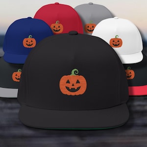 May include: A selection of flat-peak baseball caps in colours such as black, red, blue, white, and grey. Each cap has an embroidered orange jack-o'-lantern design, ideal for Halloween.