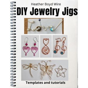 May include: A spiral-bound notebook titled "DIY Jewelry Jigs" by Heather Boyd Wire. The notebook displays examples of wire jewellery, including earrings, a dragonfly, a butterfly, and the word "Love". The text "Templates and tutorials" is also visible.