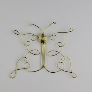 May include: A gold wire butterfly sculpture with a spiral design in the center.