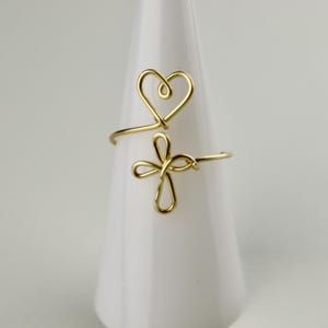 May include: Gold wire ring with a heart and cross design.