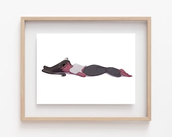 May include: A framed illustration of a person with long dark hair lying on their stomach with their head turned to the side. The person is wearing a white shirt and dark trousers.