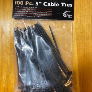 May include: A clear plastic bag containing 100 black 5-inch nylon cable ties. The black header card features the Storehouse brand name, product specifications including a 40 lb-f tensile strength, and a UL Listed certification mark.