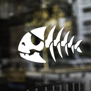 May include: White stylized fish skeleton graphic on a glass surface. The design features a detailed skull and spine, with the text "Enduring Logic" at the bottom. The background is blurred, showing an urban setting.