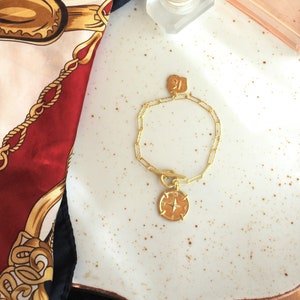 Pulsera con un medallón de brújula en una cadena ancha de cierre de palanca