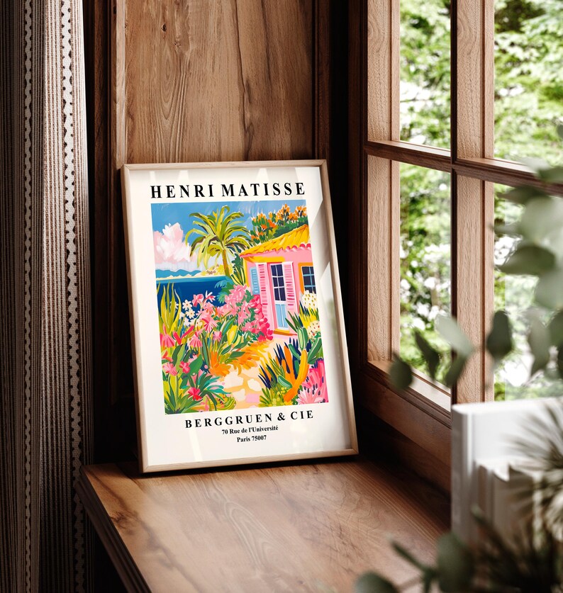 May include: A vintage poster featuring a colorful illustration of a pink house with a palm tree and flowers. The poster is titled "Henri Matisse" and includes the text "Berggruen & Cie 70 Rue de l'Universit&eacute; Paris 75007".