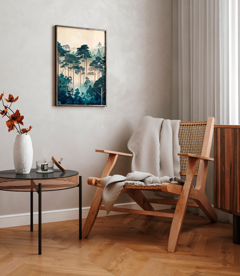 May include: A wooden chair with a woven cane seat and back, a white throw blanket draped over the seat, and a framed print of a forest scene hanging on the wall behind the chair.